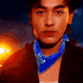 a close up of a man wearing a blue bandana and a jacket .