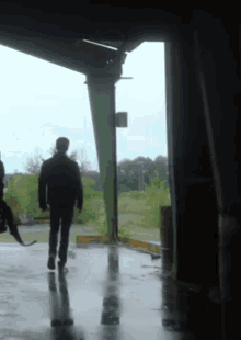 a man and a dog are walking through a doorway