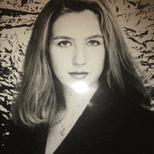 a black and white photo of a woman with a necklace around her neck
