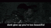 a man is holding a gun in a dark room and says dont give up you 're too beautiful