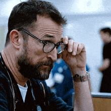 a man with a beard wearing glasses and a watch