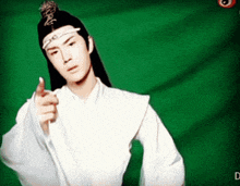 a man with long hair and a white shirt is pointing
