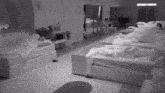 a black and white photo of a room filled with beds