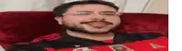 a man with glasses and a beard is wearing a red and black adidas jersey