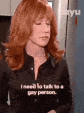 a woman with red hair is talking to a gay person in a kitchen .