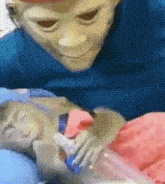 a person wearing a mask is holding a baby in a hospital bed