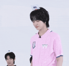 a man wearing a pink shirt and a hat with the word onion on it