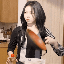 a woman in a black and white striped shirt is holding a bottle of water