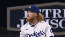 a man with a beard wearing a dodgers baseball uniform