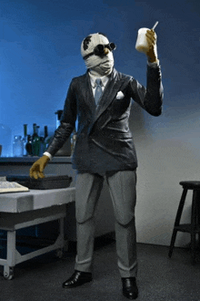 a statue of a man in a suit holding a cup