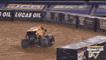 a monster truck is driving around a dirt track in front of a fence that says lucas oil