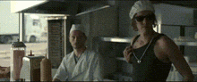 a man in a chef 's hat is standing next to a woman wearing sunglasses