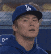 a man wearing a la dodgers hat looks at something