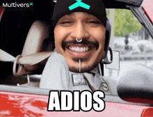 a man is sitting in a car with the word adios on the side