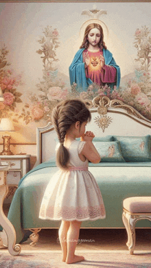 a little girl praying in front of a picture of jesus