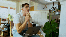 a man sitting in front of a laptop with the words it 's so bizarre man above him