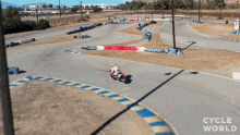 a person riding a motorcycle on a track with the words cycle world on the bottom