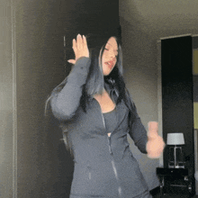 a woman wearing a black jacket is dancing in a dark room