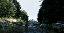 a person riding a horse down a dirt road with a sign that says ' seattle portland '