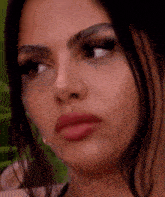 a close up of a woman 's face with a nose ring and earrings .