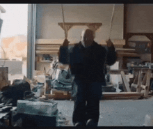 a man is swinging on a rope in a messy garage .
