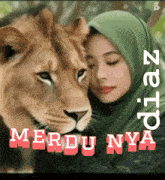 a woman in a green hijab is hugging a lion with the words merdu nya below it