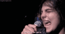 a man is singing into a microphone with his eyes closed and his mouth open .