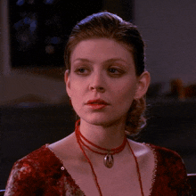 a woman wearing a red dress and a red necklace