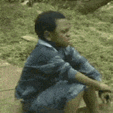 a young boy is sitting on the ground with his legs crossed .
