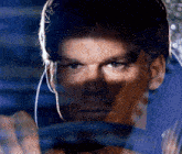 a close up of a man 's face behind a car window