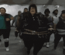 a group of people are dancing and one of them is wearing a black jacket
