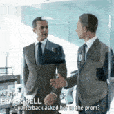 a man in a suit talks to another man in a suit and tie