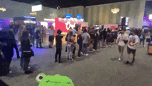 a crowd of people are gathered in a room with a sign that says ' oi ' on it