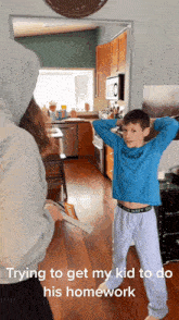 a boy wearing a blue shirt that says abercrombie is standing in a kitchen