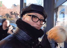 a man wearing glasses and a hat with the number 7 on the bottom right