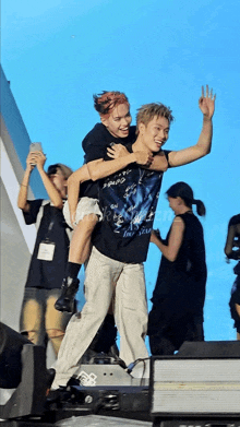 a man carrying another man on his back with a shirt that says ' i am a star '