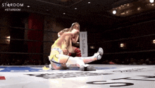 two women wrestling in a ring with a sign that says softbank on it