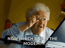 an elderly woman is looking at a laptop with the words now which one is the modem