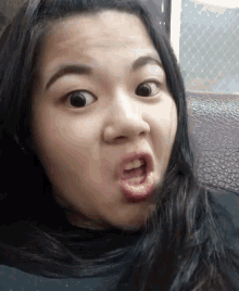 a close up of a woman making a face with her mouth open