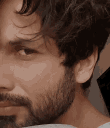 a close up of a man 's face with a beard and hair