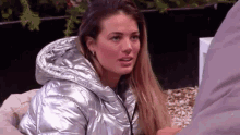 a woman in a silver jacket is sitting next to a man in a blanket .