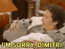 a man is laying in bed with a stuffed animal and saying i 'm sorry , dimitri .
