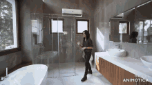 a woman stands in a bathroom with the words made in animotica on the bottom right