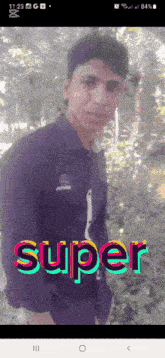 a man in a purple shirt is standing in front of trees and the word super is on the bottom right