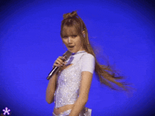 a woman singing into a microphone on a stage