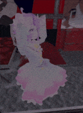 a girl with purple hair and a pink dress is dancing