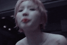a close up of a woman 's face with a flower in her mouth