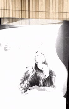 a black and white photo of a woman in front of a spotify sign