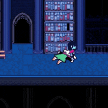 a video game character is talking to another character who is laying on the floor in front of a bookshelf .