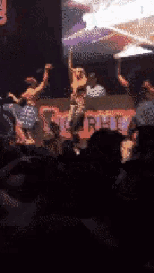a group of people are dancing on a stage in front of a sign that says nc4pet
